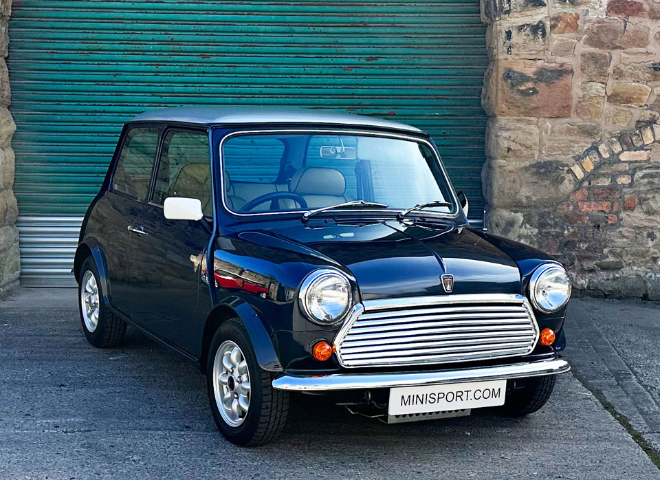 Driver's side front angled view of 1997 Rover Mini, showcasing its Anthracite Black body with silver roof and elegant design.