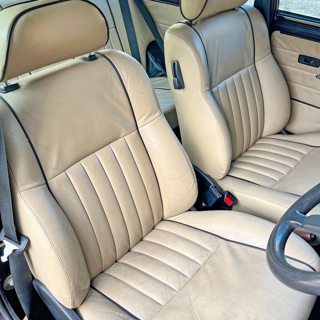 Interior view of cream leather seats with black piping in 1997 Rover Mini, offering luxurious comfort and elegance