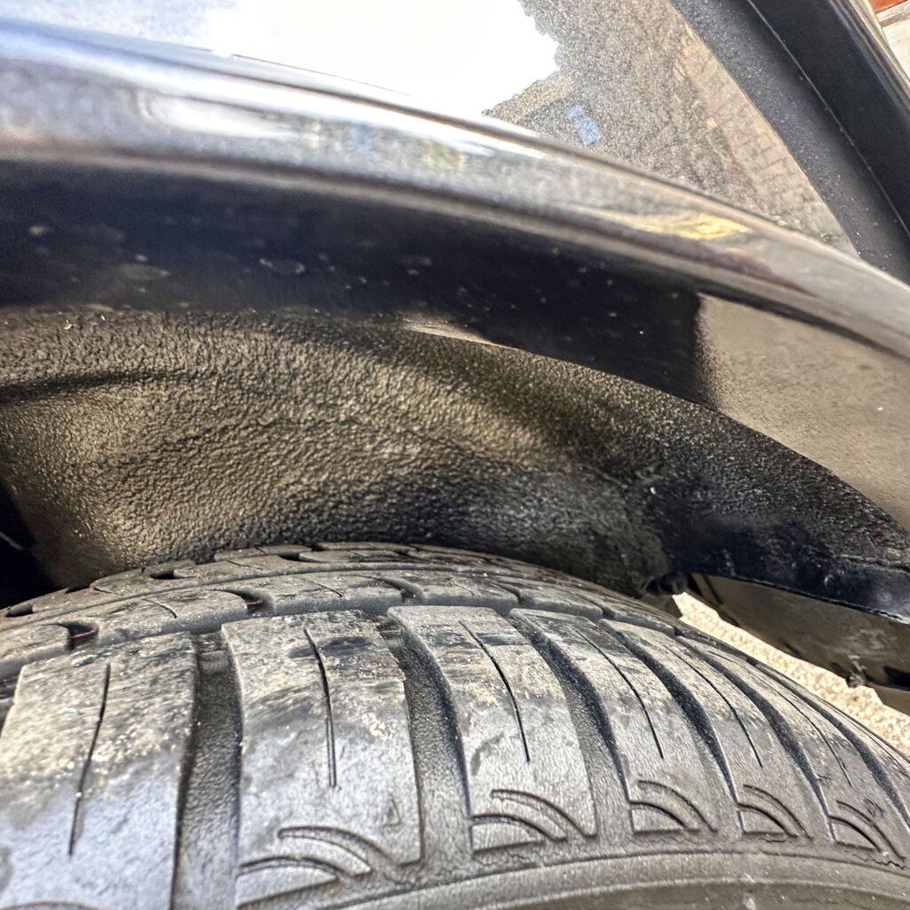 Close-up of the wheel arch on 1997 Rover Mini, showcasing its 12" alloy wheels and new 145/70 R12 tyres