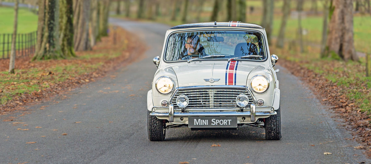Classic Mini EV fitted with a wavy front grille, Mk1 style bumper overriders and P700 headlights..