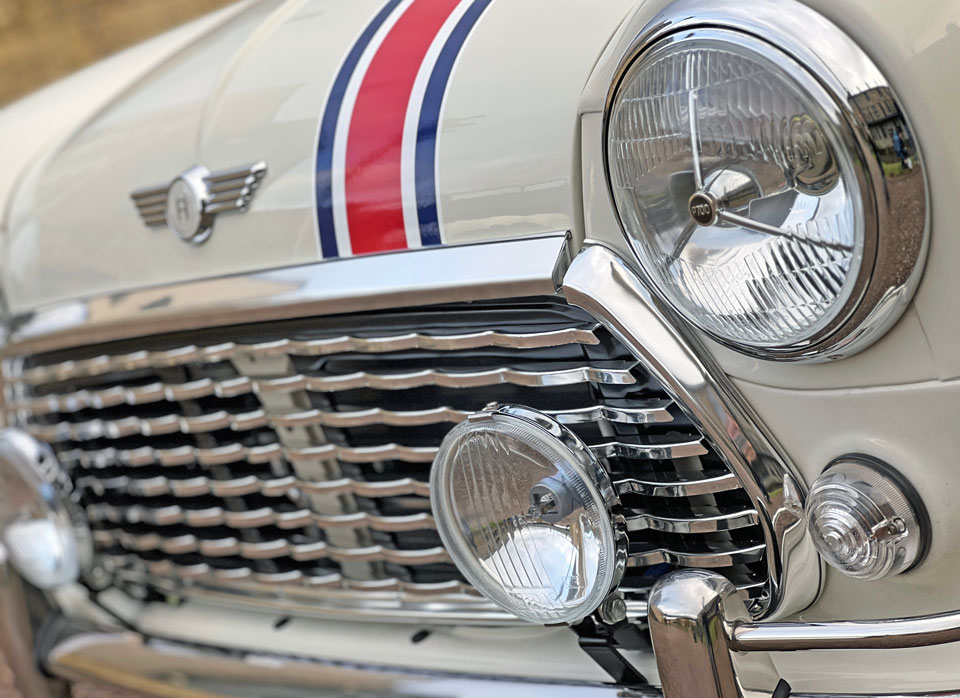 Close-up of the MK1 style wavy grille and P700 lights on 1999 Mini Cooper 40 EV 'Merlin', adding a vintage touch to its design.