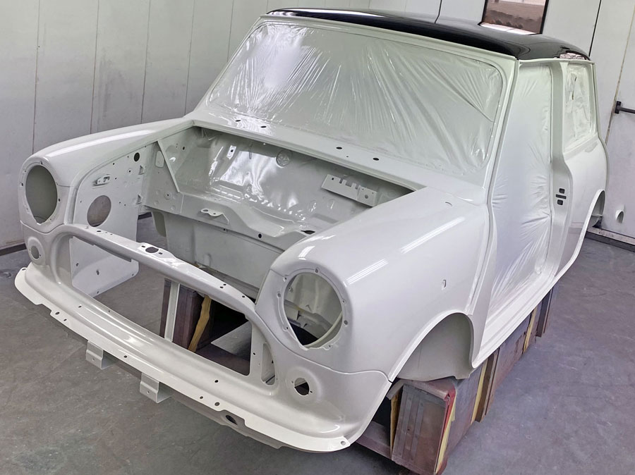 White British Motor Heritage body shell with a black roof, meticulously crafted for classic Mini Cooper restoration
