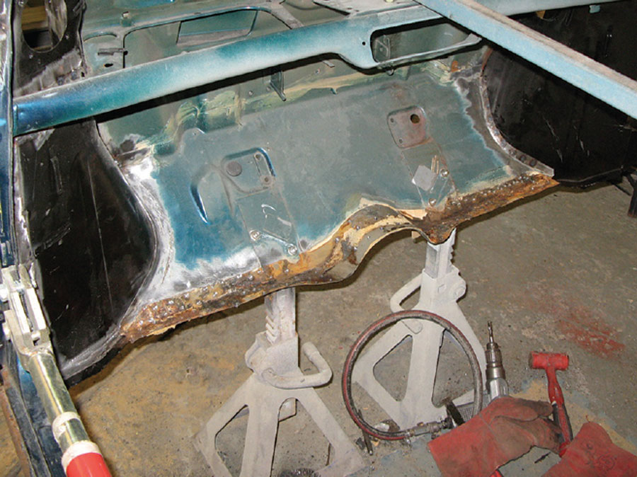 Rusted floor section cut out of a Mini shell, exposing corrosion damage.