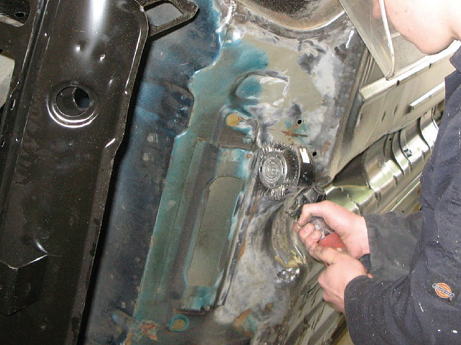 Thorough surface preparation of a Mini shell before applying primer for long-lasting repairs.