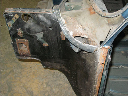 Damaged scuttle panel of a Mini removed for repair, showing extensive body filler use.