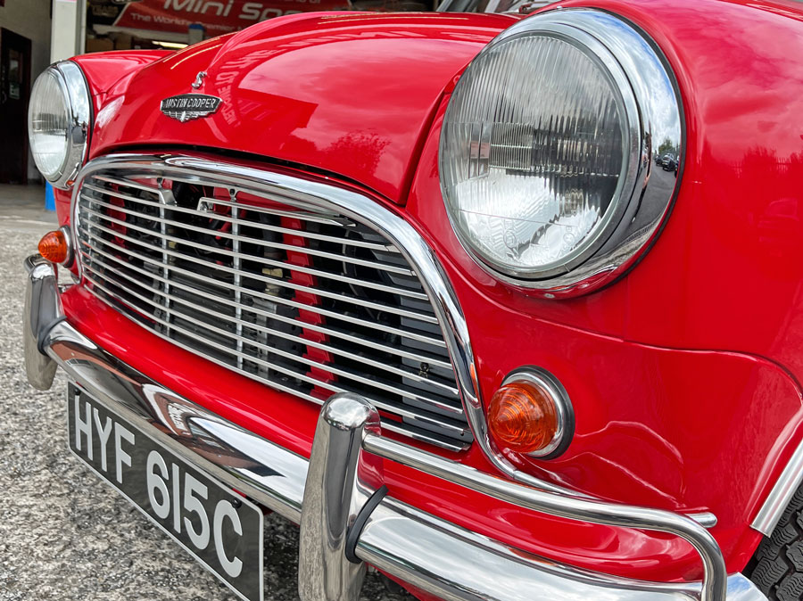 Front grille and headlights of a 1965 Austin Mini Cooper S in tartan red.