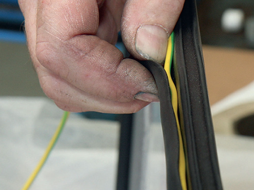 Heavy gauge cable being fed into the window seal channel of Bogus 2.