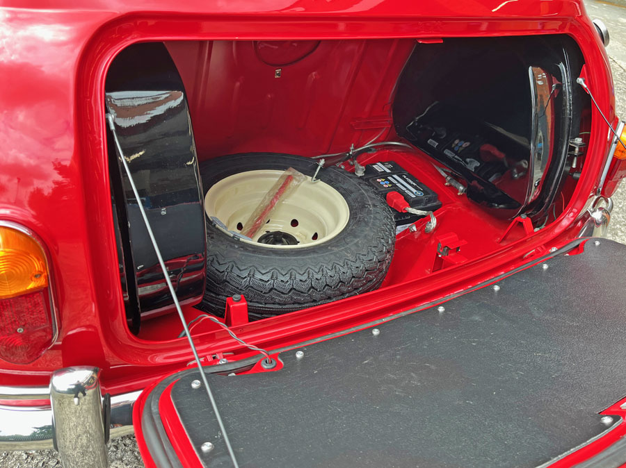 Interior view of the boot of a 1965 Austin Mini Cooper S in tartan red, showcasing the boot space.