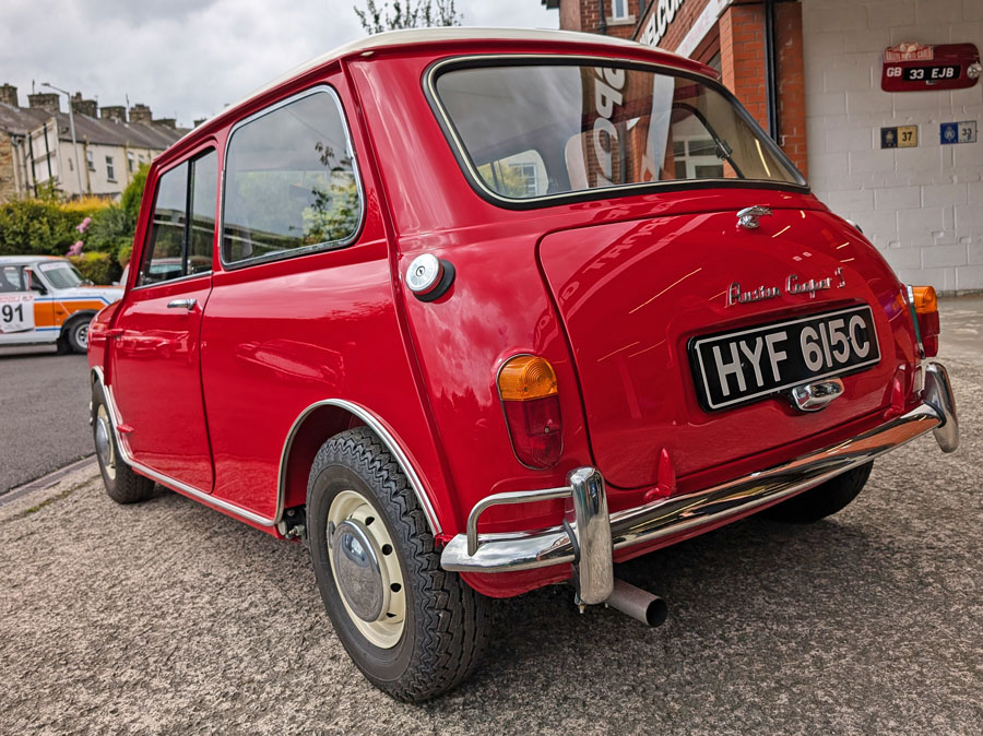Rear view of a 1965 Austin Mini Cooper S in tartan red with a white roof.