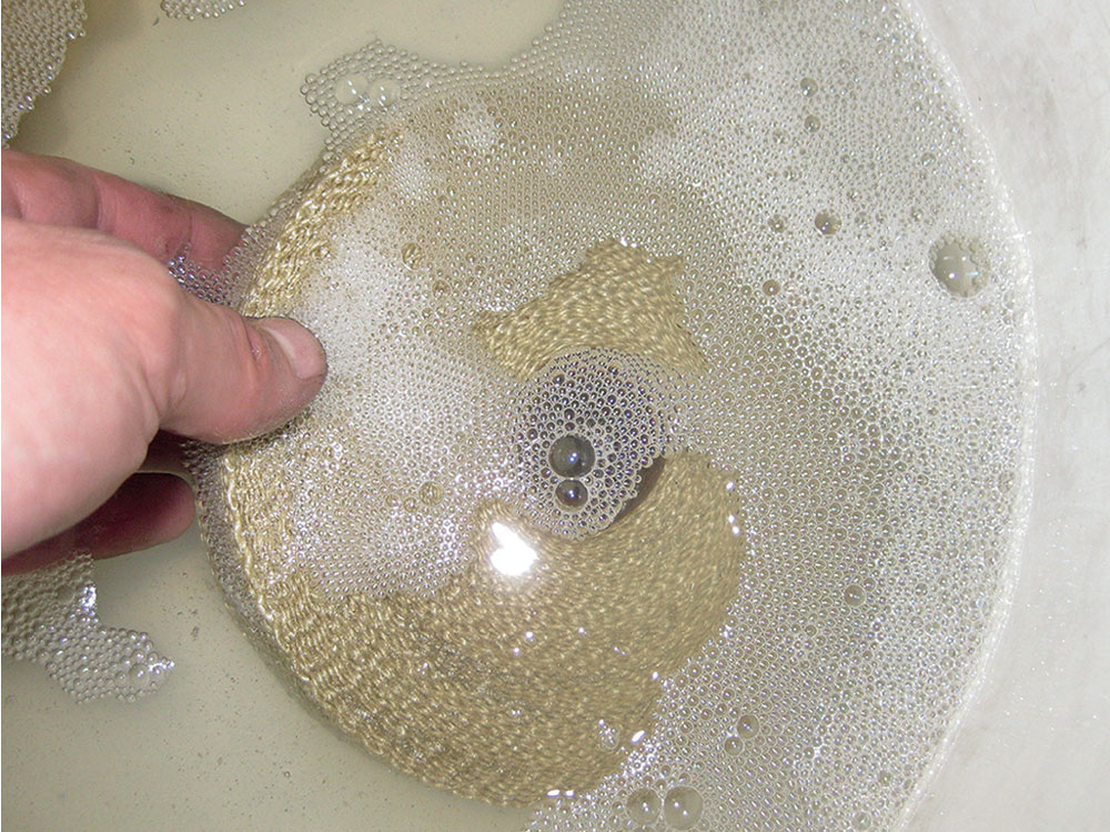 Exhaust wrap soaking in water to increase flexibility before application on the exhaust manifold.