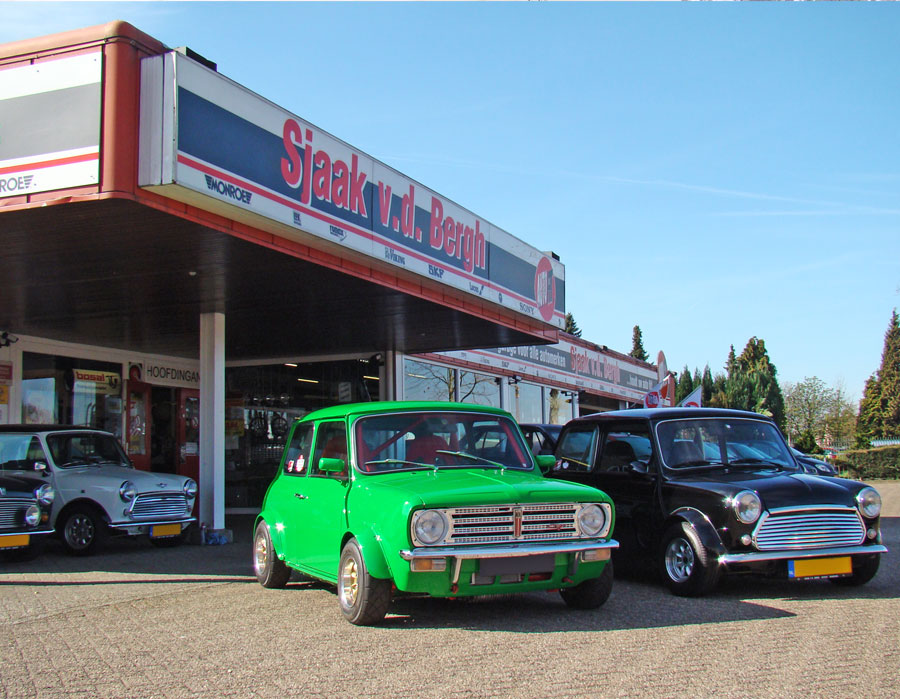Green Classic Mini next to Black classic Mini outside classic mini center